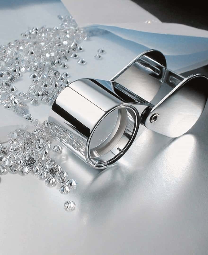 Fülle an geschliffenen weißen Diamanten mit Hand-Lupe Diamanten mit Lupe