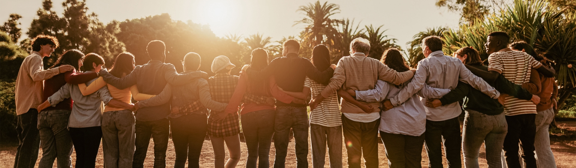 Gruppe von Menschen hält sich im Arm bei Sonnenuntergang juwelier-leicht-engagement